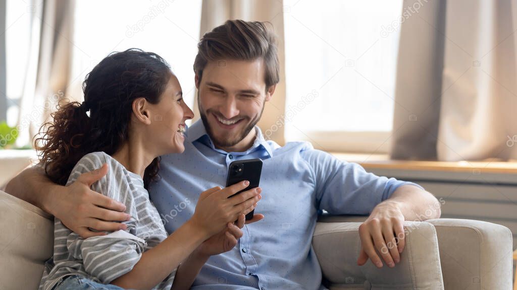 Happy young couple using modern smartphone together