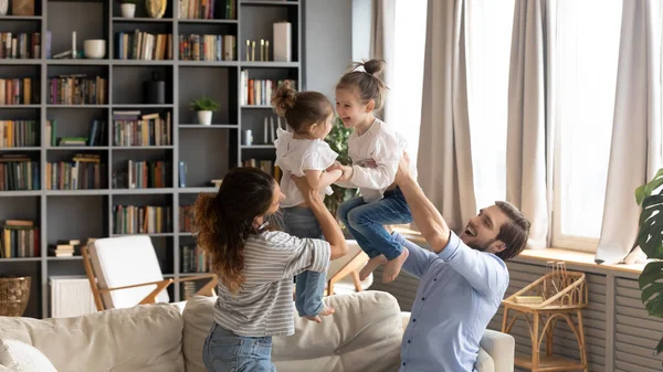 Happy parents have fun playing with small daughters — Stock Photo, Image