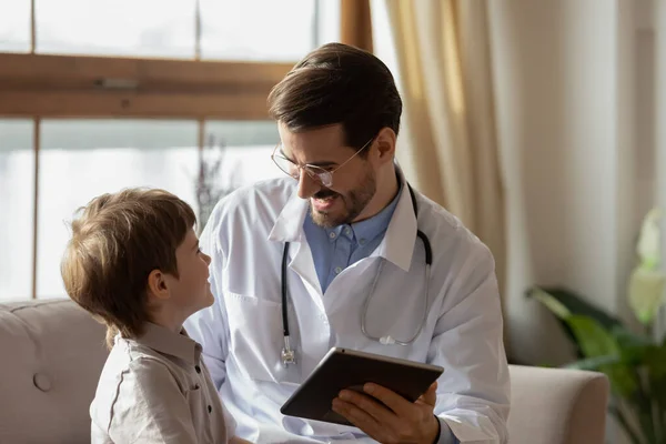 Manlig pediatriker kontroll liten pojke patient som använder tablett — Stockfoto