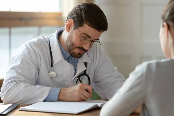 Manlig läkare fylla patienten anamnes i medicinska kort — Stockfoto