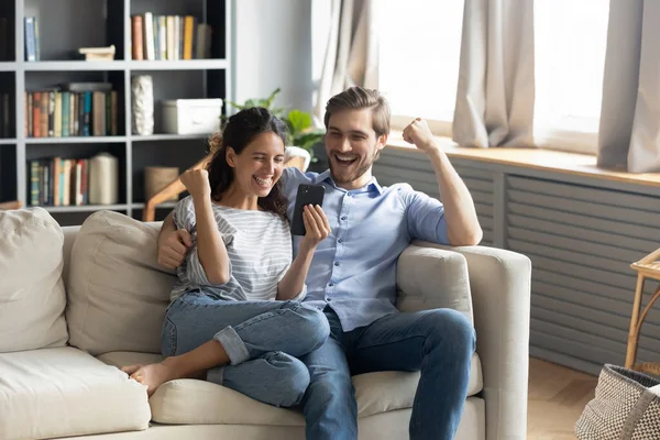 Overgelukkig jong stel triomf winnen online loterij op cel — Stockfoto