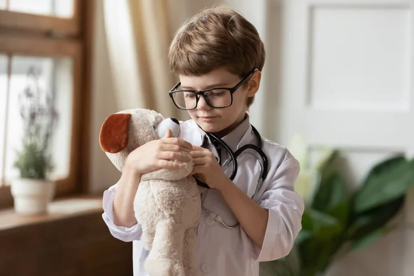 Petit garçon enfant en blanc guérir petit jouet en peluche — Photo