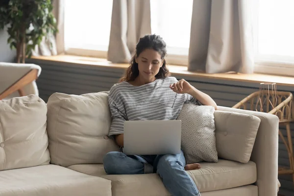 Jovem mulher relaxar no sofá usando laptop — Fotografia de Stock