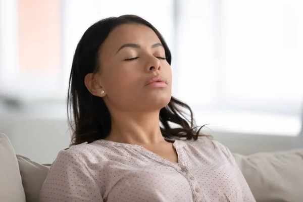 Mulher africana calma descansando olhos fechados respirando ar fresco umedecido — Fotografia de Stock