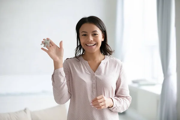 African woman showing keys from new own home feels happy