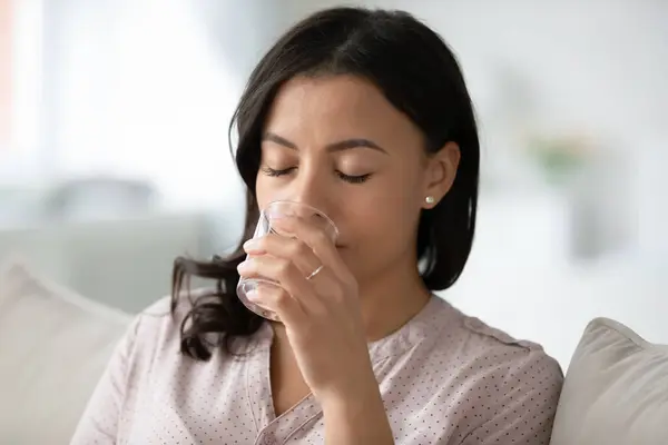 Mixed-race woman holding glass drinking fresh water closeup view — Stock Photo, Image