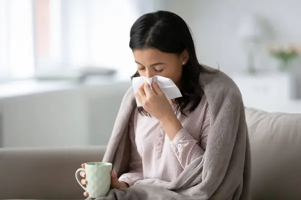 Stock image African woman drinking cold remedy blow runny nose use tissue