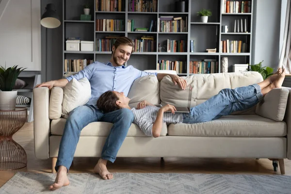 Счастливая пара расслабиться на диване с помощью ноутбука — стоковое фото