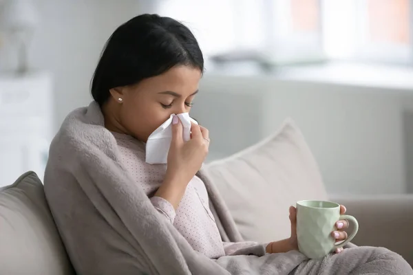 Africano mulher envolto em xadrez, sopro nariz bebidas frio medicina — Fotografia de Stock