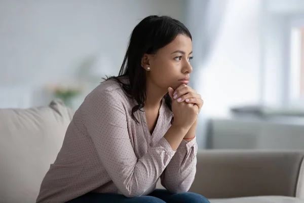 Sad African woman sit on sofa thinking of life troubles — Stock Photo, Image