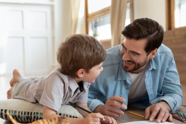 Sevgi dolu baba, küçük tatlı anaokulu çocuğuyla çizim yapıyor.