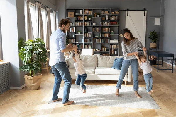 Boldog szülők táncolnak a kislányukkal otthon. — Stock Fotó