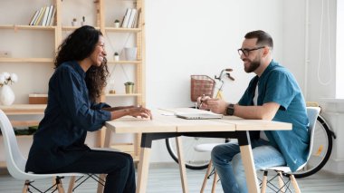 Mutlu İnsan Kaynakları Müdürü gülerek yeni Afro-Amerikan adayıyla röportaj yapıyor..