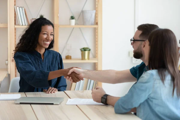 Real estate agent shaking hands with happy young couple. — Stock Photo, Image