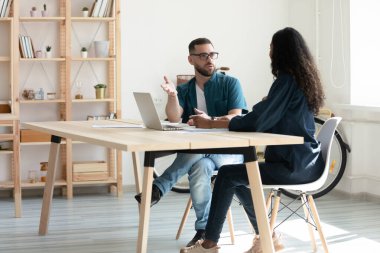 Güvenilir sakallı iş adamı toplantı odasında dizüstü bilgisayar kullanarak iş kadınıyla konuşuyor..