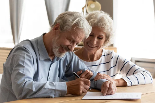 Feliz pareja jubilada de mediana edad firmando contrato de matrimonio . — Foto de Stock