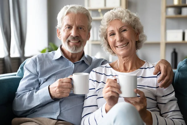 Χαμογελώντας συνταξιούχοι οικογενειάρχες σύζυγοι απολαμβάνοντας τεμπέλης πρωί. — Φωτογραφία Αρχείου