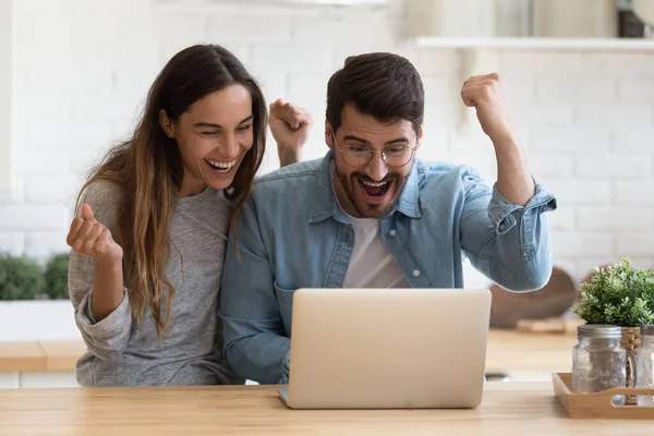 Радостная молодая пара побеждает в лотерее онлайн — стоковое фото