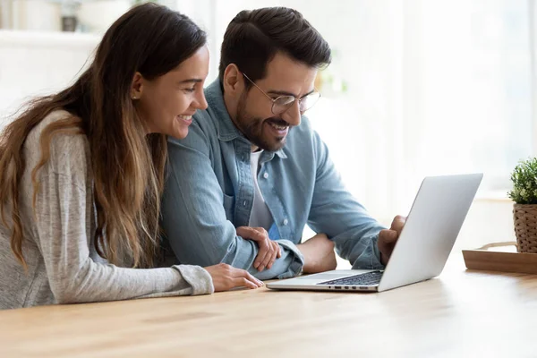 Pareja feliz se divierten usando el ordenador portátil moderno en casa — Foto de Stock