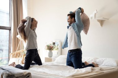 Çok mutlu bir milenyum çifti yatak odasındaki yastık savaşında iyi eğlenceler.