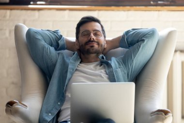 Genç adam rahat koltukta dinleniyor. Evde dinleniyor.