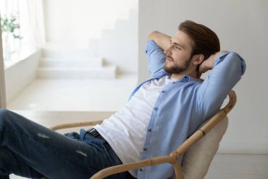 Gülümseyen genç adam, sandalyede rahatla.