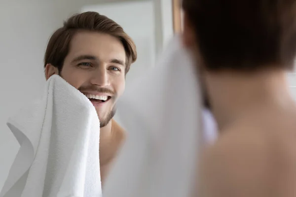 Smiling young man washing in morning in bathroom — Stock Photo, Image