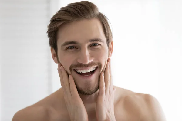 Portrait of smiling young man touch healthy face skin — Stock Photo, Image