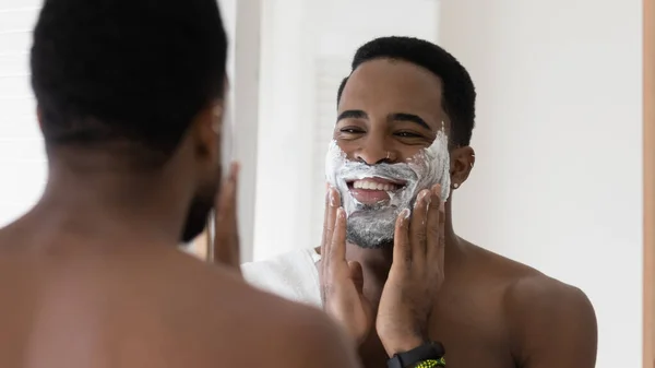 African American man use foam shaving beard in bathroom — Stock Photo, Image