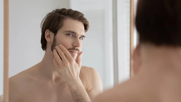 Young Caucasian man apply cream in home bathroom — Stock Photo, Image
