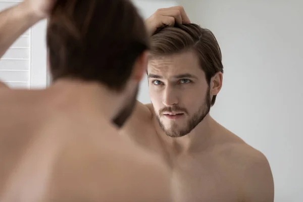 Anxious young man worried about hair loss or receding hairline — Stock Photo, Image