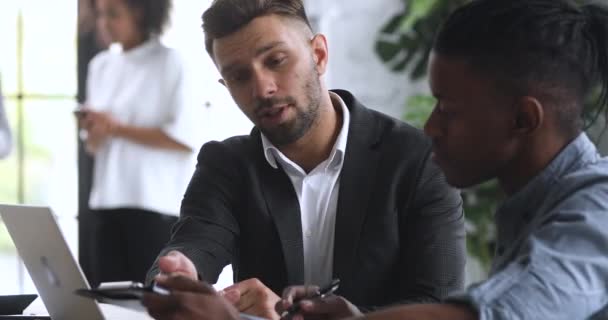 Un hombre de negocios inteligente y seguro que consulta a un joven cliente afroamericano . — Vídeo de stock