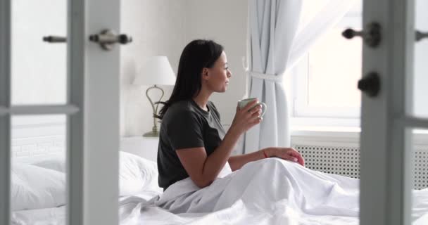 幸せなアフリカ系アメリカ人女性がベッドでコーヒーを飲む. — ストック動画