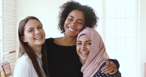 Bonding souriant jeune mixte équipe féminine regardant la caméra . — Video