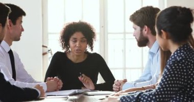 Ciddi Afro-Amerikan takım lideri meslektaşlarıyla beyin fırtınası toplantısı yapıyor..