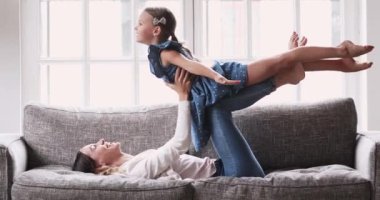 Mutlu çok nesilli aile içeride kanepede jimnastik yapıyor..