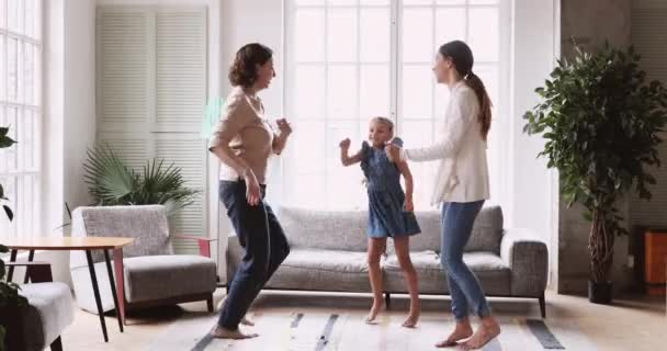 Plaisir multigénérationnel famille dansant pieds nus dans le salon . — Video