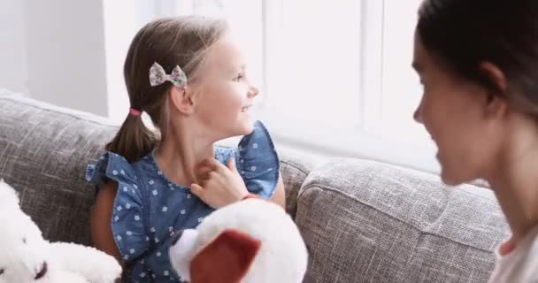 Grappig klein schattig meisje spelen speelgoed met gemengde ras nanny. — Stockvideo