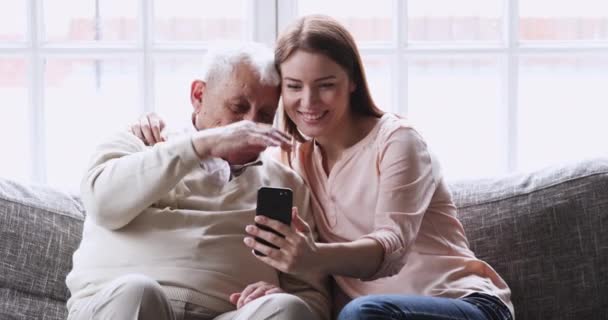 Χαρούμενη οικογένεια διαφορετικών γενεών που διασκεδάζουν, χρησιμοποιώντας εφαρμογές φωτογραφιών για κινητά. — Αρχείο Βίντεο