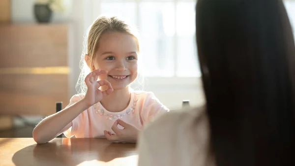 Feliz niña practicar el lenguaje de señas con mamá —  Fotos de Stock