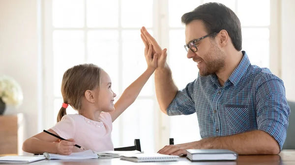 Щасливий тато і маленька дочка відзначають успіх навчання разом — стокове фото