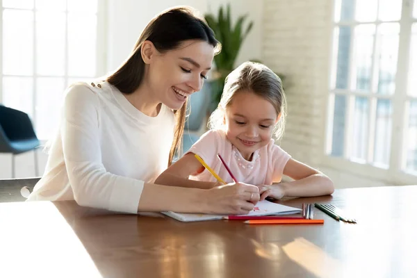 Happy mom and small daughter painting together — Stock Photo, Image