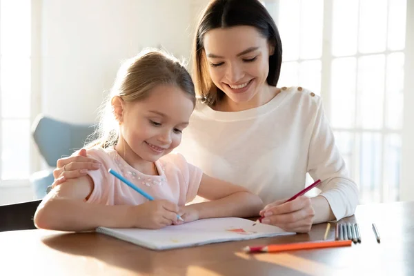 Sonriente madre e hija pequeña pintando juntas —  Fotos de Stock