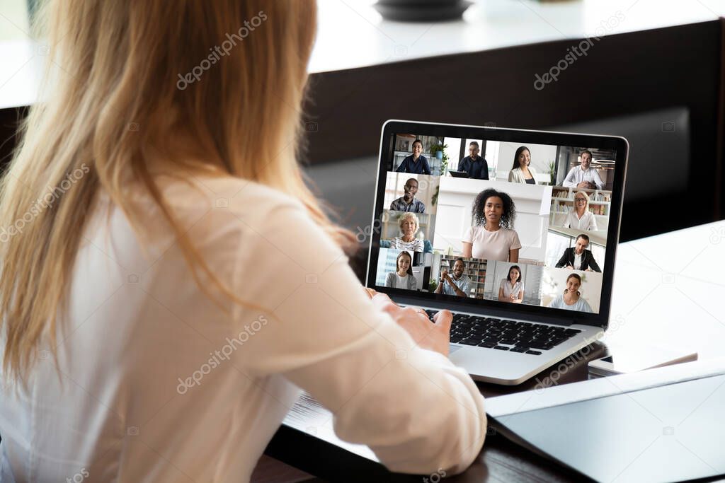 Back view of female employee have video call on laptop