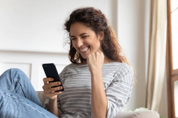 Usmívající se žena drží telefon, ukazuje ano gesto, slaví úspěch — Stock fotografie