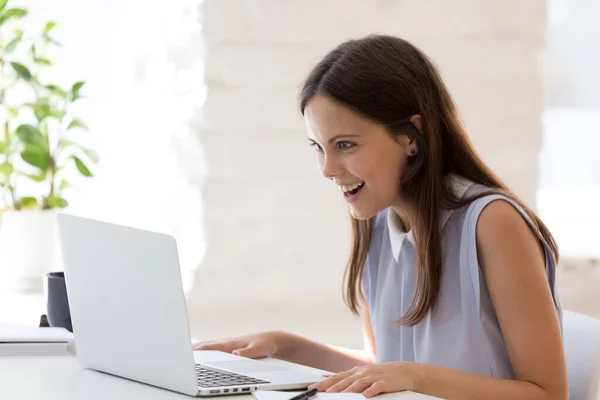 Verrast jonge vrouw geschokt door bericht op laptop — Stockfoto