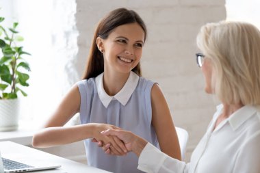 Mutlu meslektaşlar iş yerinde el sıkışır.