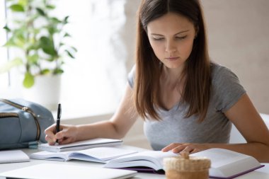 Akıllı kız öğrenci evde el yazısı okuyor.