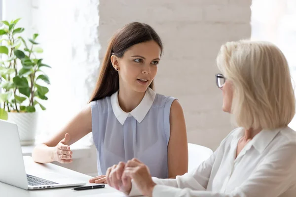 女性社員が説明会で同僚とビジネスアイデアを話し合う — ストック写真