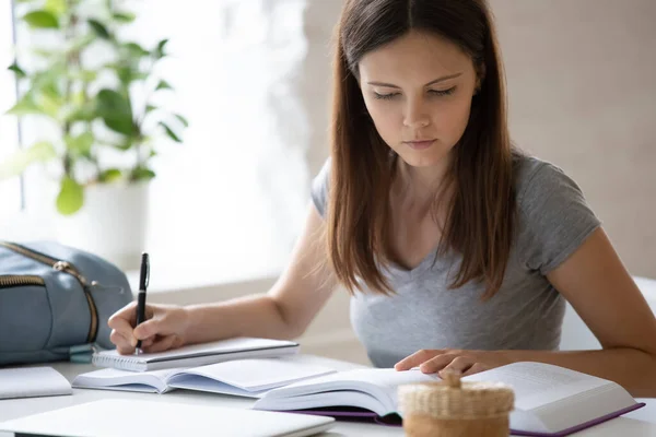 Slimme vrouwelijke student die thuis handschrift studeert — Stockfoto